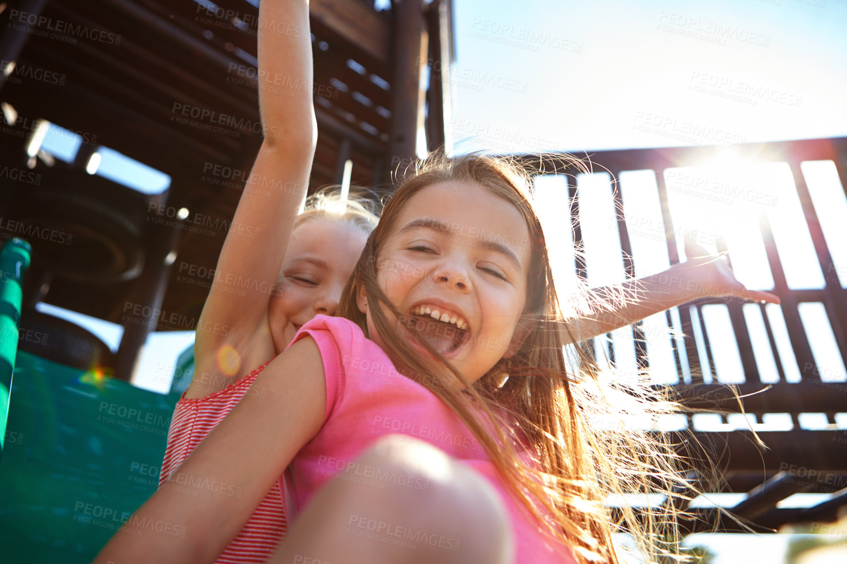 Buy stock photo Shot of two little girls on a slide at the play park