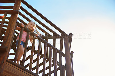 Buy stock photo Shot of a little girl playing on a jungle gym