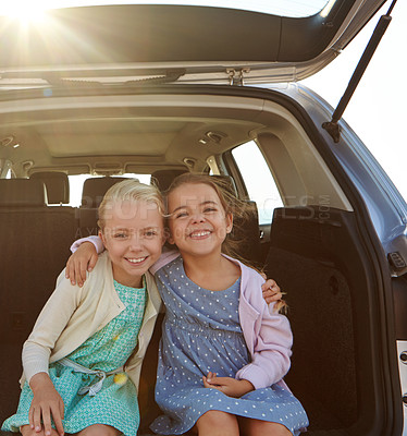 Buy stock photo Shot of two little girls sitting in the trunk of a car