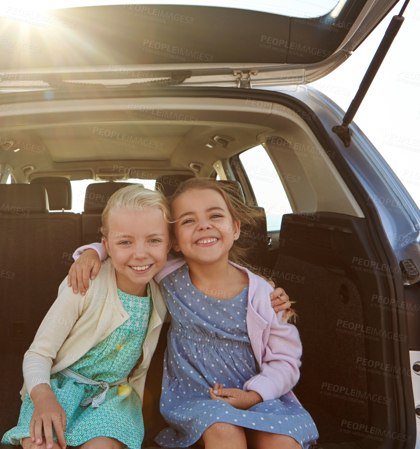 Buy stock photo Shot of two little girls sitting in the trunk of a car