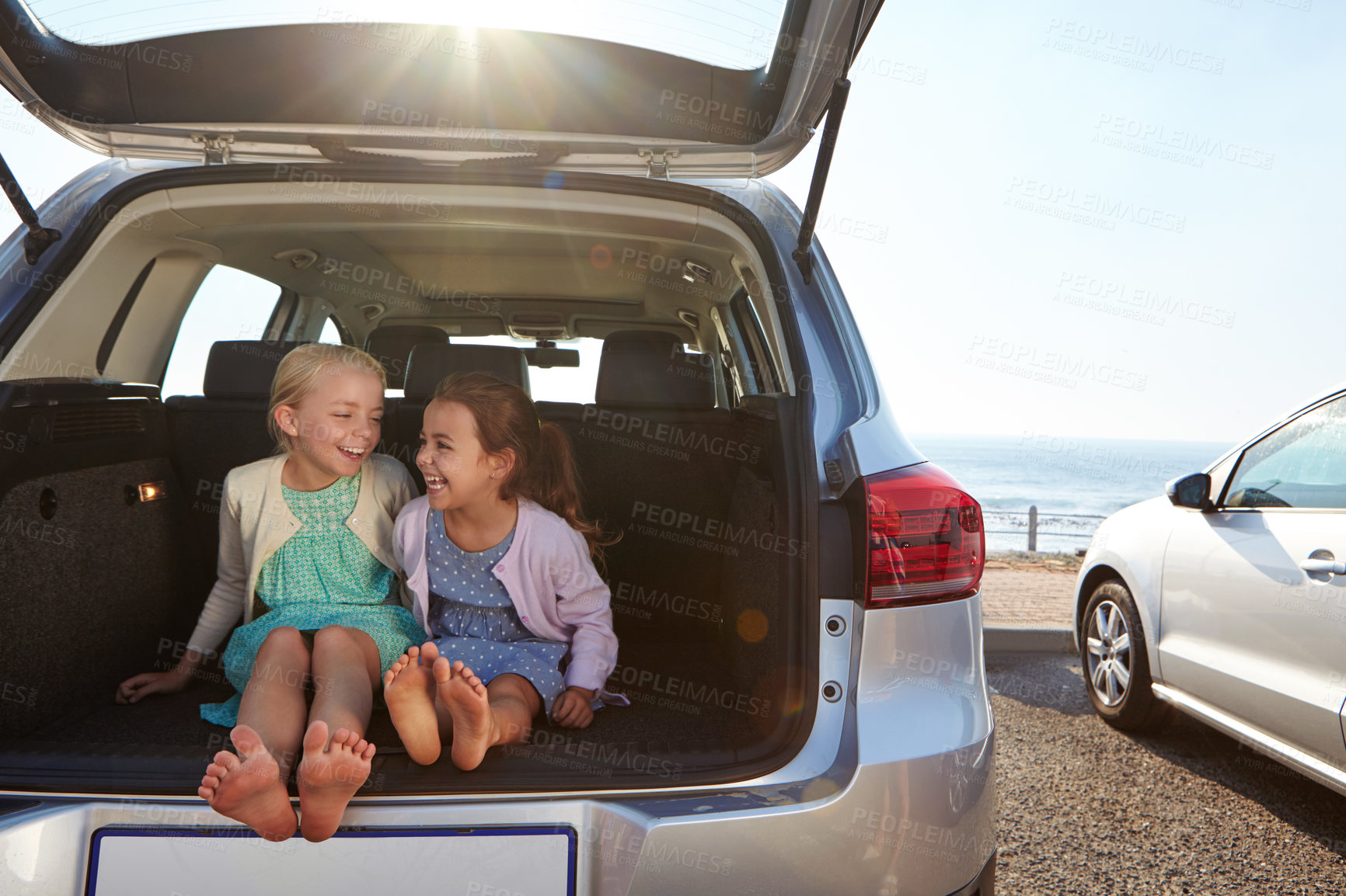 Buy stock photo Shot of two little girls sitting in the trunk of a car