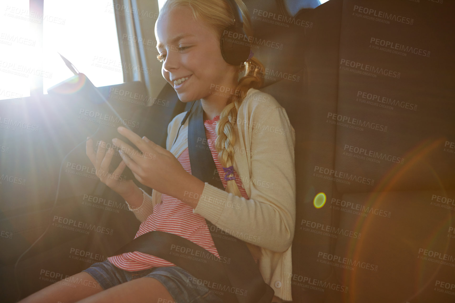 Buy stock photo Headphones, tablet and girl with road trip, adventure or journey for vacation in car. Tech, streaming and child with audio in vehicle for holiday, transport or travel with flare for entertainment
