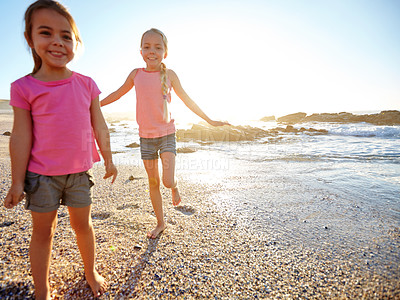 Buy stock photo Shot of two little girls having fun on the beach