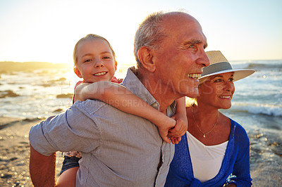 Buy stock photo Shot of a grandparents enjoying a day at the beach with their granddaughter