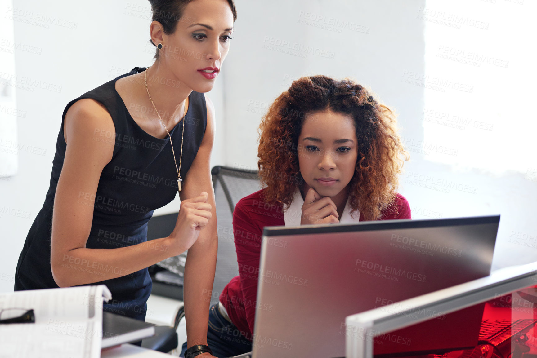 Buy stock photo Shot of two businesswoman working together at a computer in an office