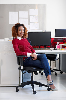 Buy stock photo Portrait of a young woman sitting at her workstation in an office