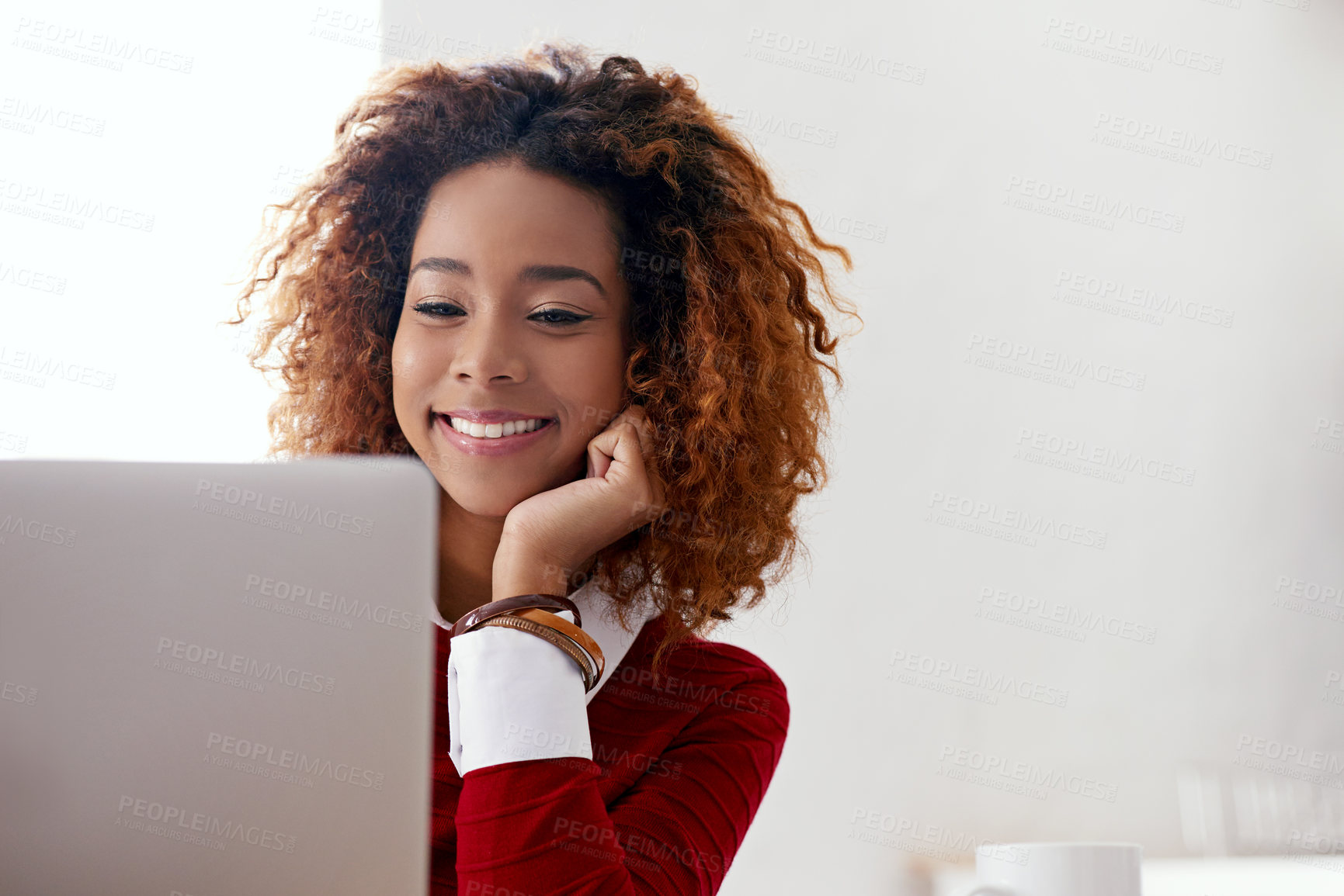 Buy stock photo Shot of a young woman working on a laptop in an office