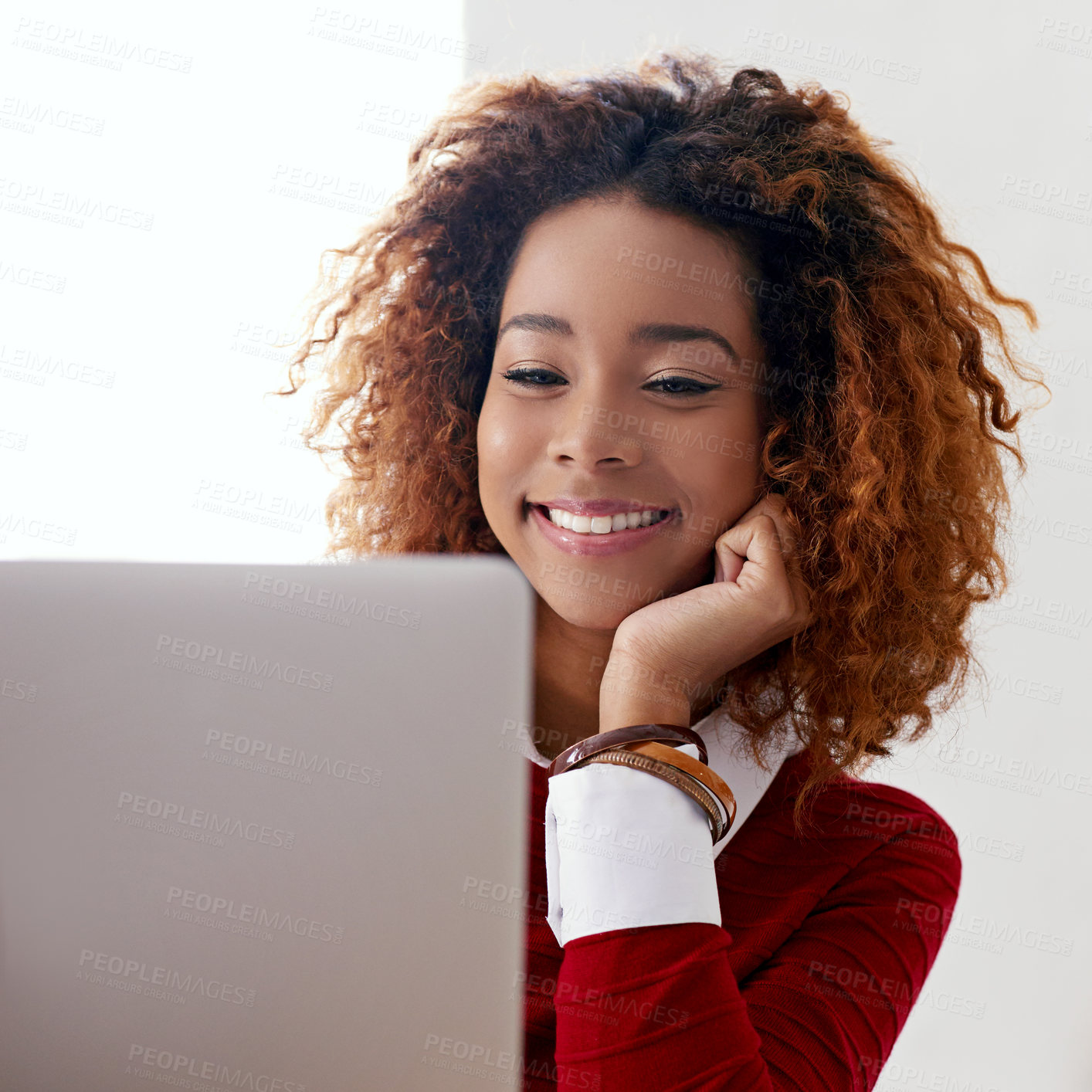 Buy stock photo Shot of a young woman working on a laptop in an office