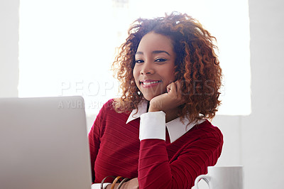 Buy stock photo Shot of a young woman working on a laptop in an office