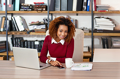Buy stock photo Shot of a young woman sending at text while working on a laptop in an office