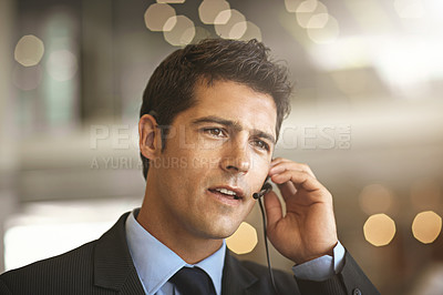 Buy stock photo Cropped shot of a businessman communicating using his headset