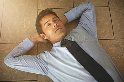 Buy stock photo High angle shot of a businessman lying on his office floor