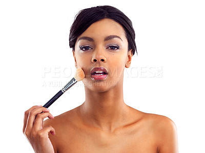 Buy stock photo Studio portrait of an attractive young woman holding a makeup brush to her face