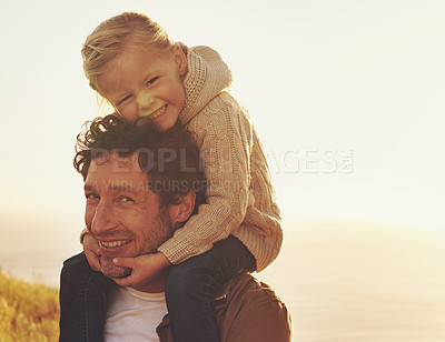 Buy stock photo Shot of a father carrying his little girl on his shoulders while walking outdoors