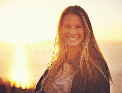 Buy stock photo Sunset, nature and portrait of woman by ocean for adventure, relaxing and enjoy weekend outdoors. Happy, smile and person with flare on hill for holiday, vacation and travel destination in evening