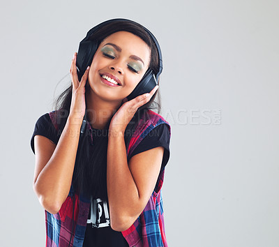 Buy stock photo Young woman or headphones in studio with music for streaming, relaxed or listening with joy. Female student or electronics on backdrop with audio for online podcast, natural smile with freedom