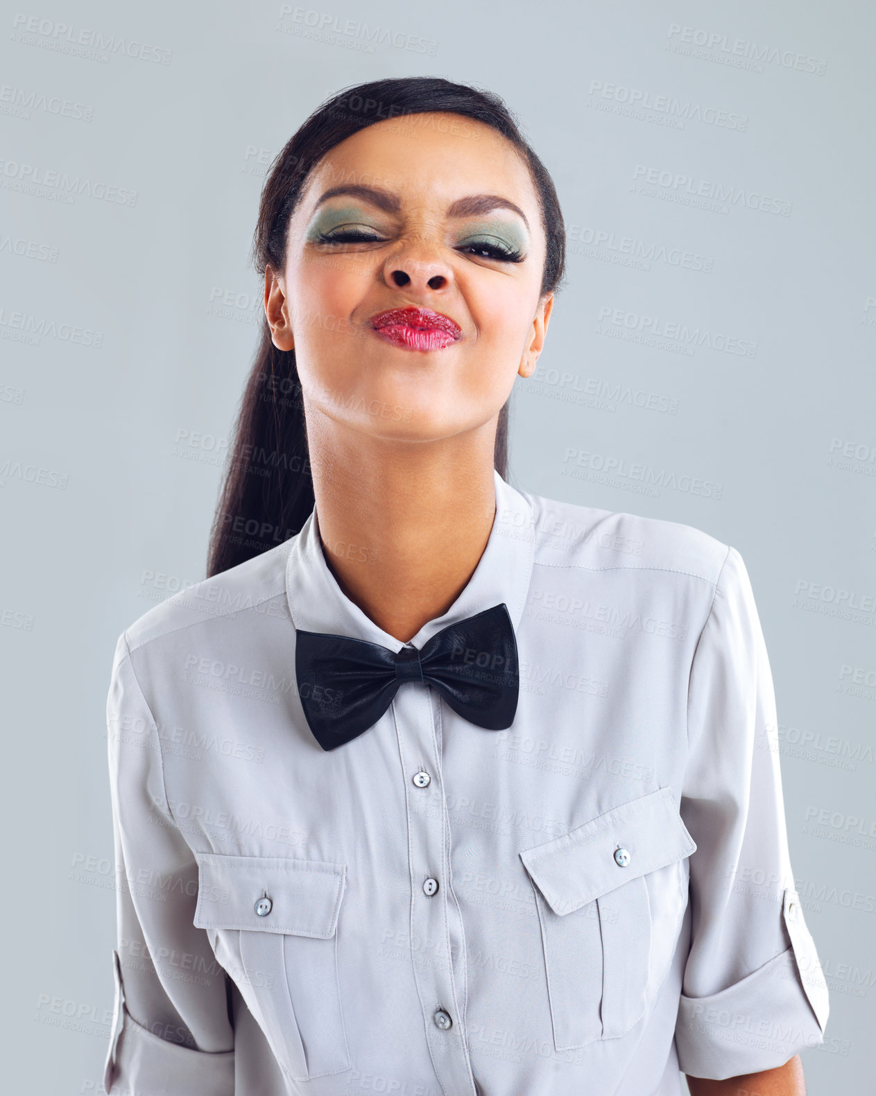 Buy stock photo Cropped portrait of a trendy young woman making a face against a gray background