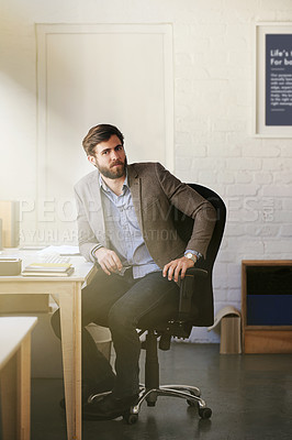 Buy stock photo Shot of a young businessman sitting in his office