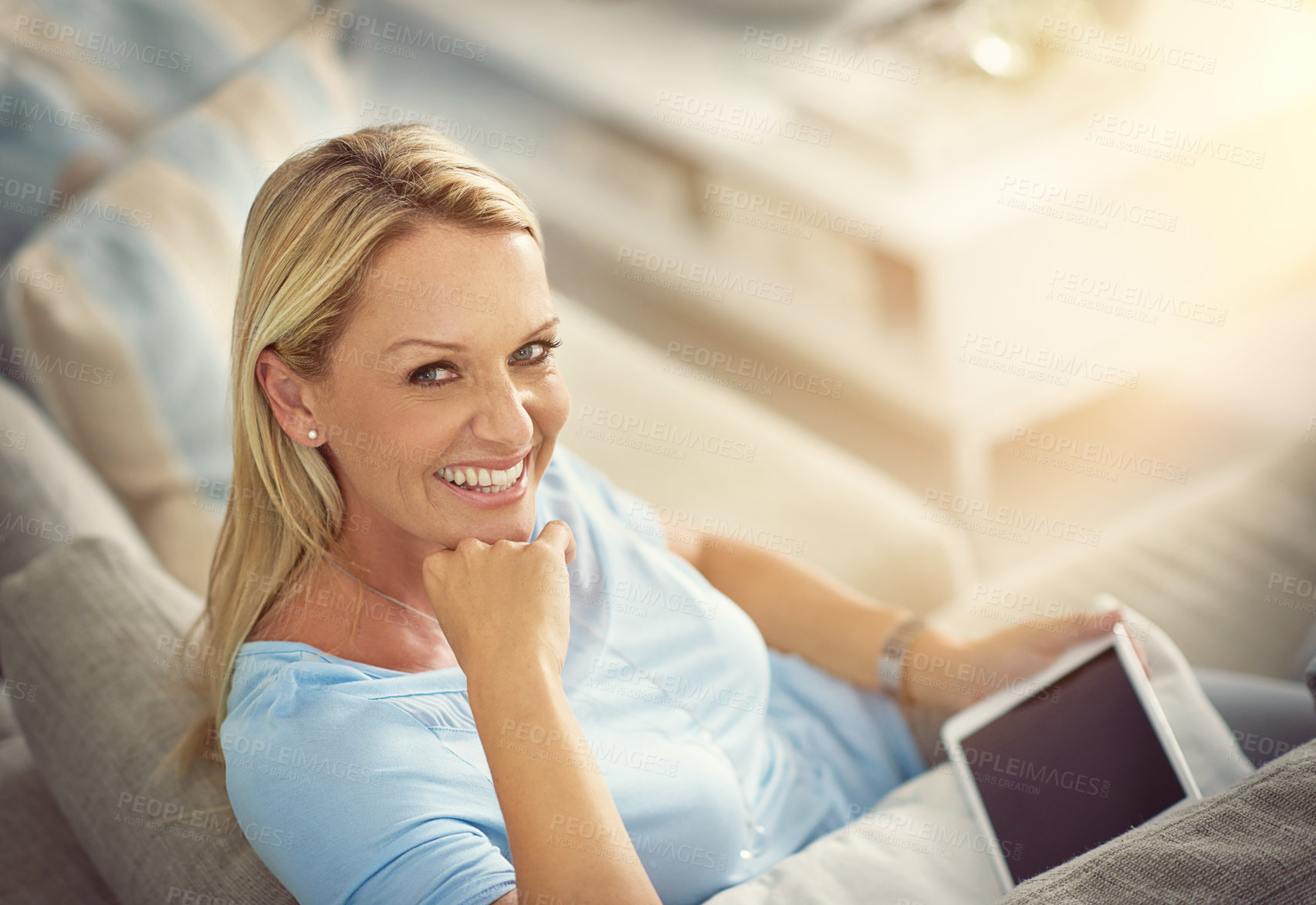 Buy stock photo Shot of a mature woman relaxing on the sofa with a digital tablet