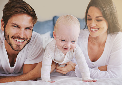 Buy stock photo Happy family, baby and parents on bed for love, care and quality time together at home. Mom, dad and cute newborn child relaxing in bedroom for happiness, support and smile for development of kids 