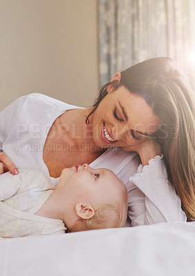 Buy stock photo Mother, playful and care with baby on bed for bonding, love and relaxing together in bedroom. Lens flare, happy woman and daughter for childhood development, support and nursery in apartment
