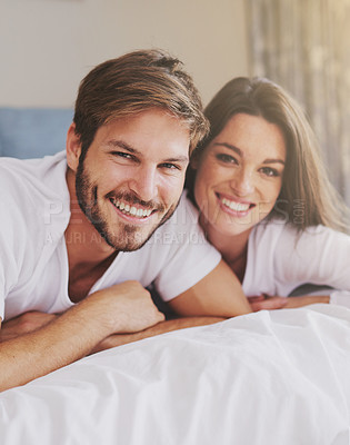 Buy stock photo Smile, hotel and portrait of couple on bed for relaxing, bonding and resting together on vacation. Happy, romantic and young man and woman laying in bedroom at modern apartment or home on weekend.