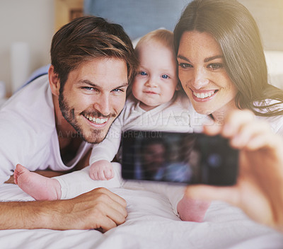 Buy stock photo Happy family, parents and selfie of baby on bed in home for love, care and quality time together. Mother, father and newborn child smile for photograph, fun memory and happiness of bonding in bedroom