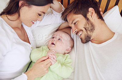 Buy stock photo Top view of happy family, parents and baby in bedroom for love, care and quality time together at home. Mother, father and newborn kid relax on bed with support, childhood development and happiness