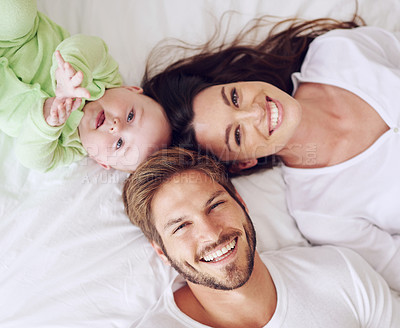 Buy stock photo High angle portrait of a young couple and their baby boy in the bedroom