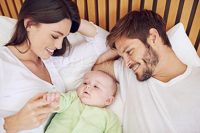 Buy stock photo Top view, parents and smile of baby in bedroom for love, care and quality time together at home. Happy mother, father and family relax with cute newborn kid on bed for support, development and joy
