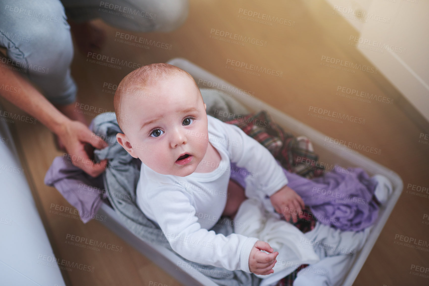 Buy stock photo Laundry, washing and portrait of baby in basket in home for multitasking, housekeeping and housework. Family, childhood and above of parent with newborn for cleaning, hygiene and maintenance on floor