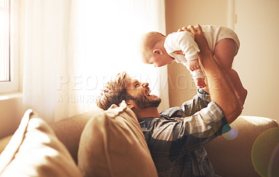 Buy stock photo Cropped shot of a young father and his baby boy in the living room