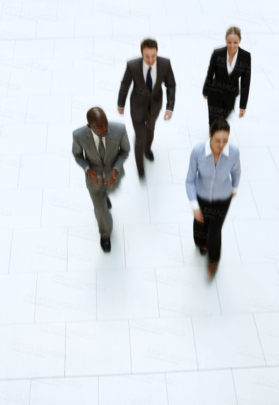 Buy stock photo High angle shot of a group of businesspeople walking through the office lobby