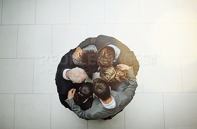 Buy stock photo High angle shot of a group of businesspeople standing in a huddle