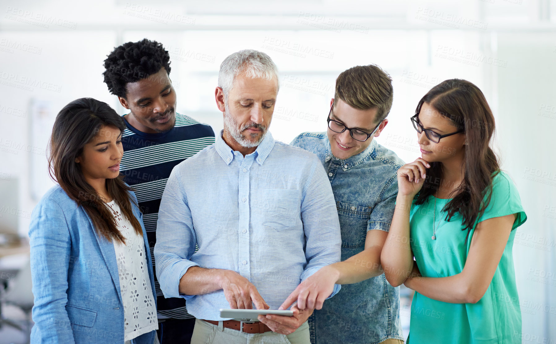 Buy stock photo Cropped shot of a group of creative businesspeople looking at a tablet