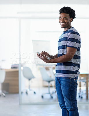 Buy stock photo Cropped portrait of a young businessman using his tablet in the office corridor