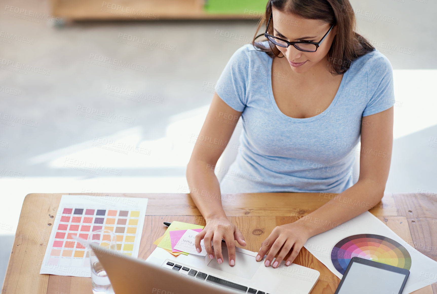 Buy stock photo Cropped shot of a female designer working on a project at her desk