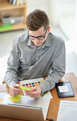 Buy stock photo Shot of a male designer working on a creative project at his desk