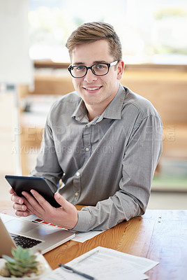 Buy stock photo Shot of a male designer using a digital tablet while sitting at his office desk