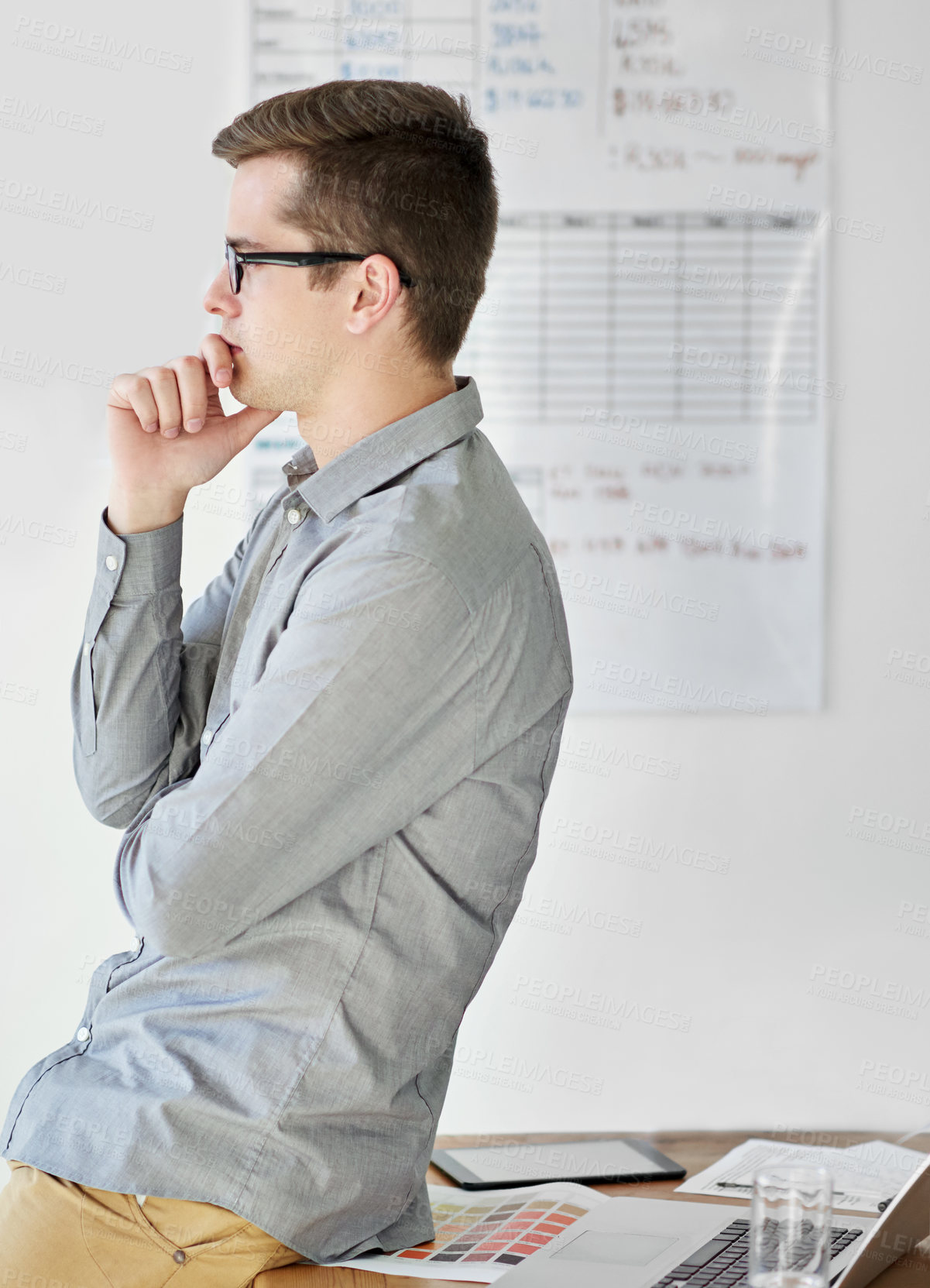 Buy stock photo Shot of a young male designer looking thoughtful in his office