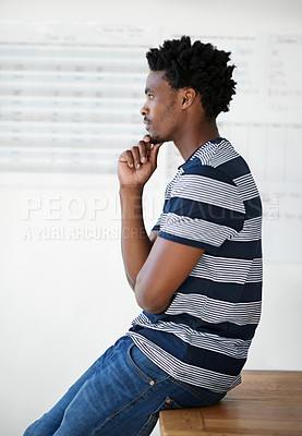 Buy stock photo Shot of a young male designer looking thoughtful in his office