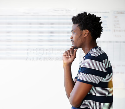 Buy stock photo Shot of a young male designer looking thoughtful in his office