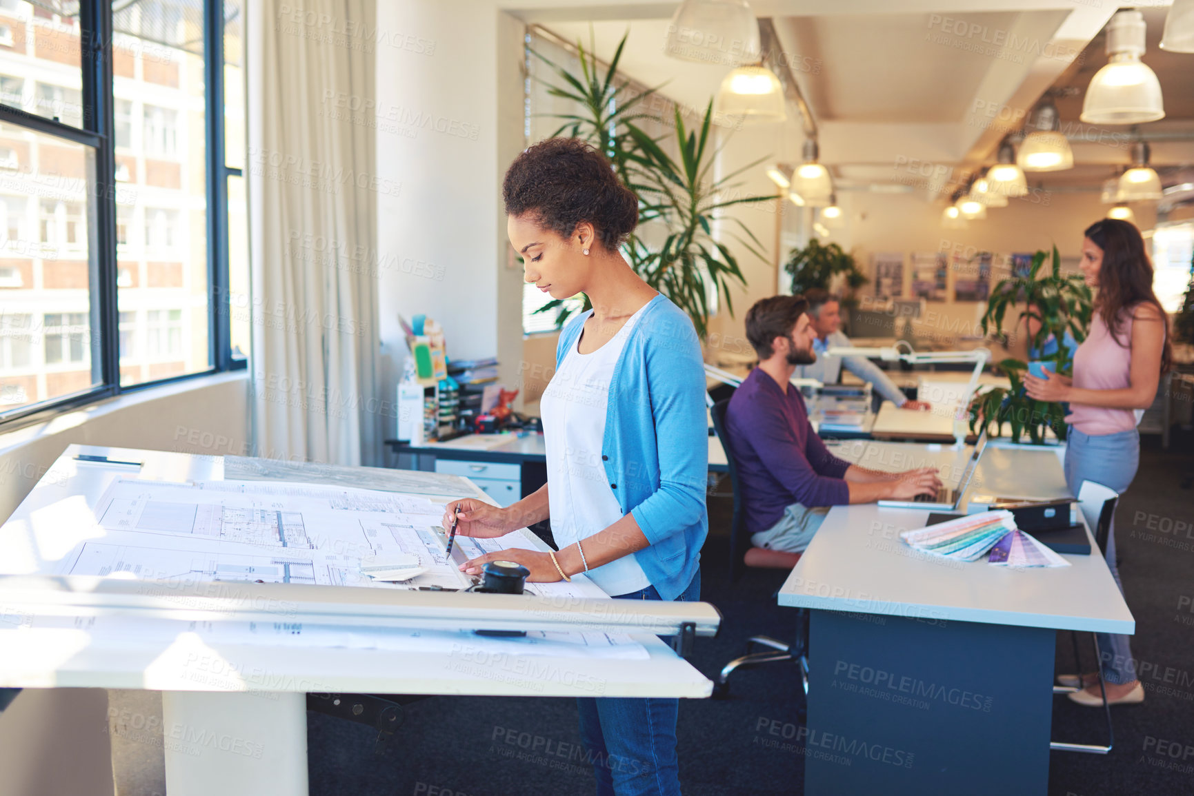 Buy stock photo Cropped shot of a young architect working on her drafting table