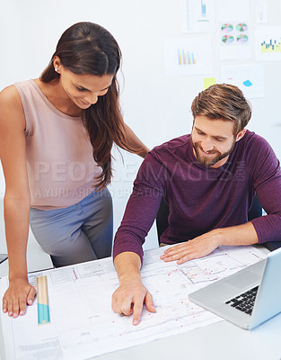 Buy stock photo Cropped shot of two young architects looking over some building plans