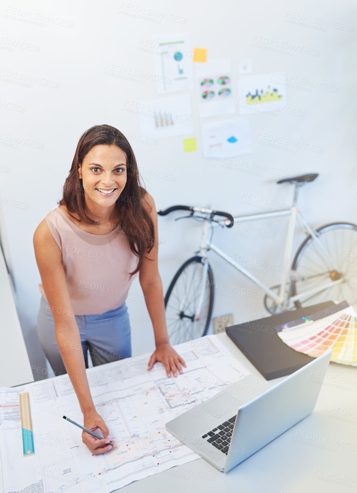 Buy stock photo Cropped portrait of a young architect looking over some building plans