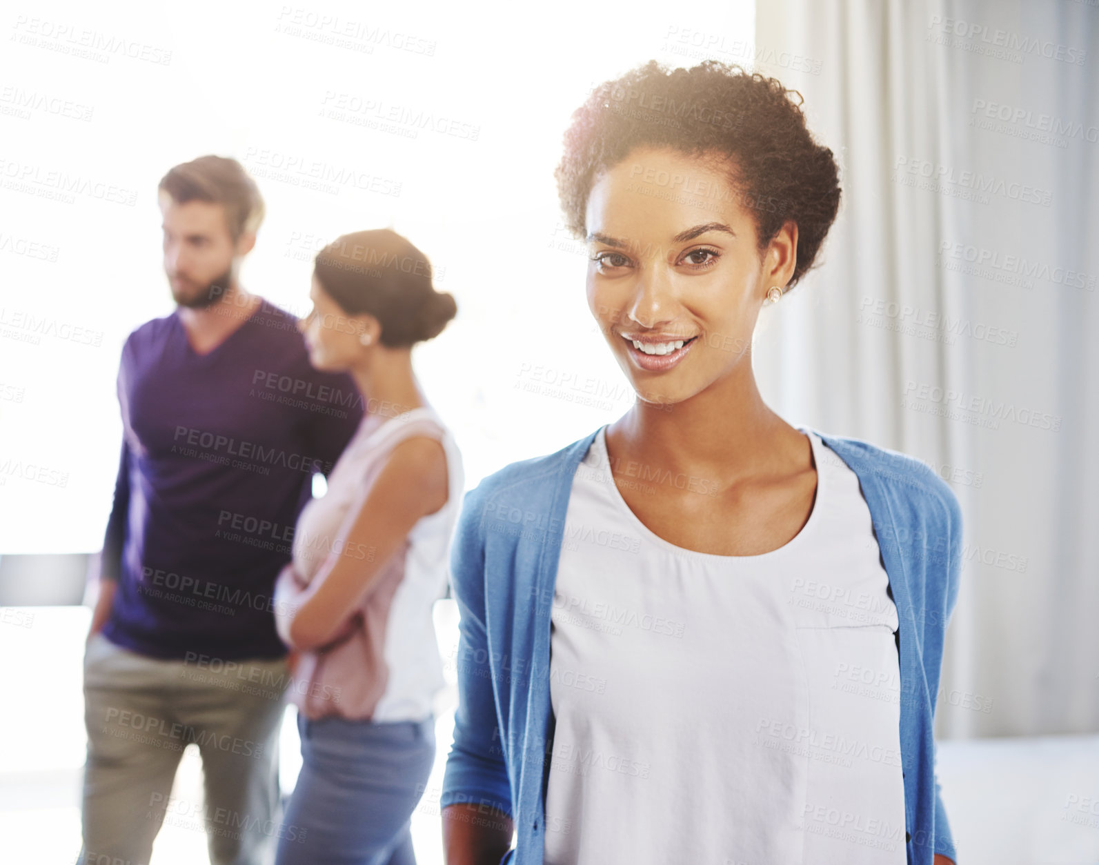 Buy stock photo Portrait of a young businesswoman with her colleagues standing in the background