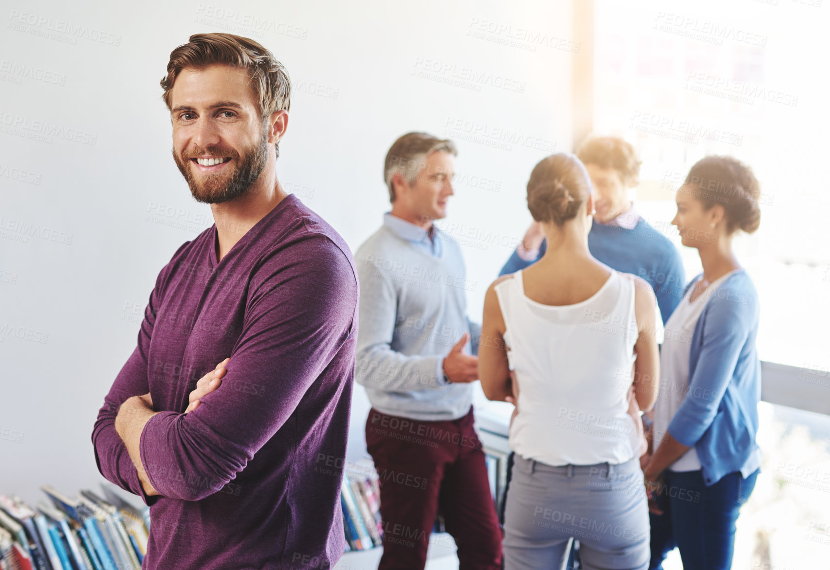 Buy stock photo Portrait of a young businessman with his colleagues standing in the background