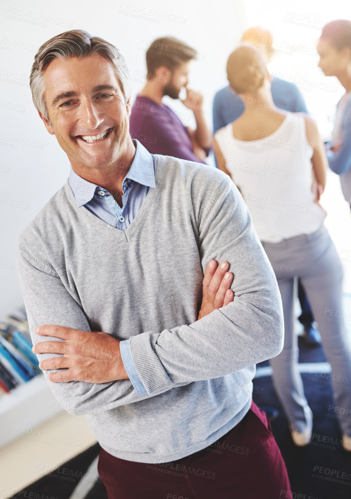 Buy stock photo Portrait of a mature businessman with his colleagues standing in the background