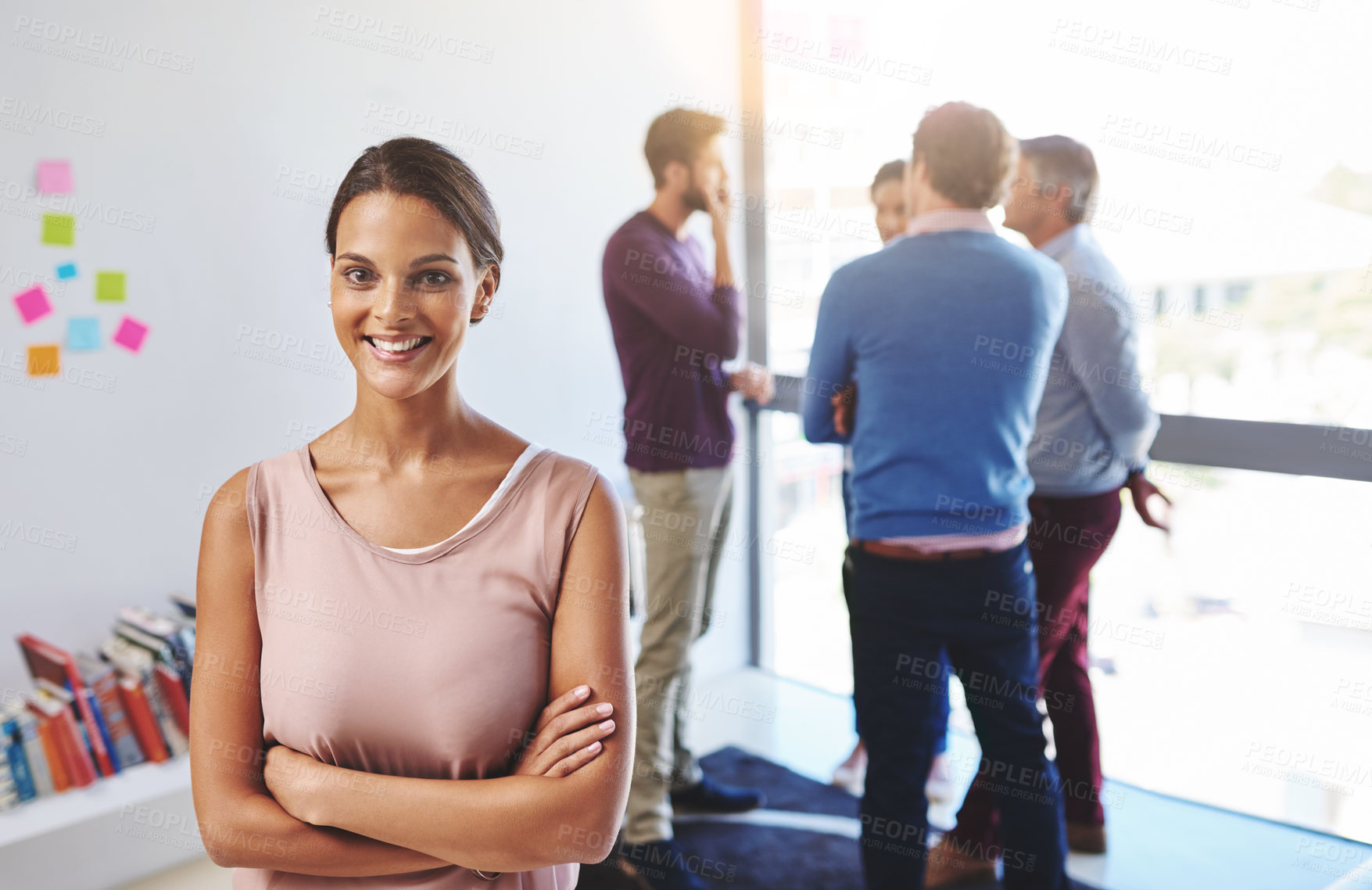 Buy stock photo Portrait of a young businesswoman with her colleagues standing in the background