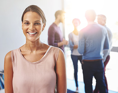 Buy stock photo Portrait of a young businesswoman with her colleagues standing in the background